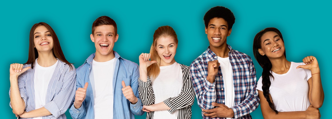 A group of five young people, three girls and two boys. They all point their thumbs at themselves.